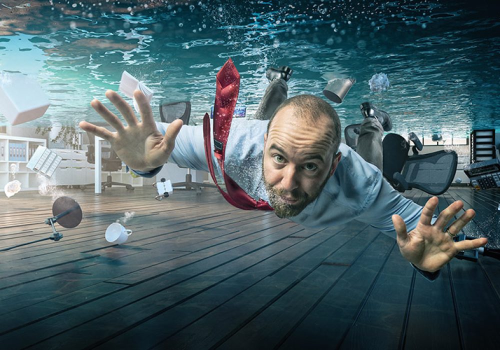 businessman swimmin a flooded office